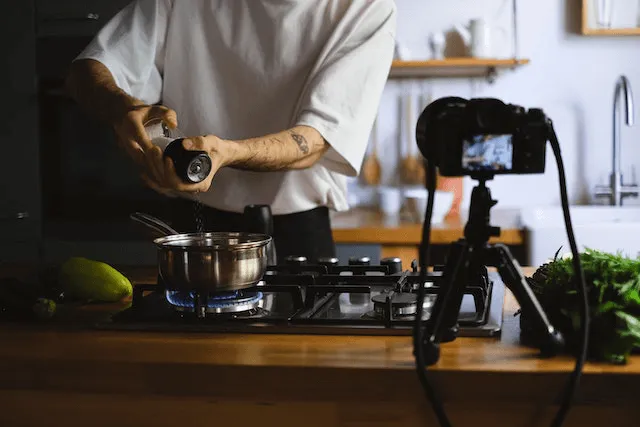 A man shows how to make cooking videos while a camera films
