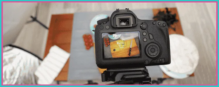 A photo showing a camera taking a photo of a cutting board and knife.